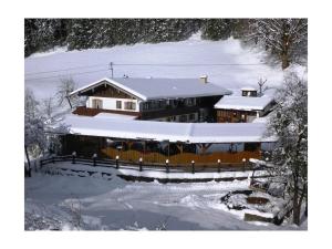 a house covered in snow with a fence at Untersberg in Punzenlehen in Engedey