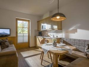 a living room with a table and a kitchen at Holiday apartment Tristnerblick in the Huaterhof in Laimach