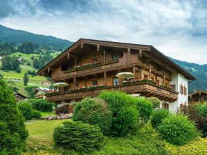a large wooden house with flowers on the balcony at Holiday apartment Tristnerblick in the Huaterhof in Laimach