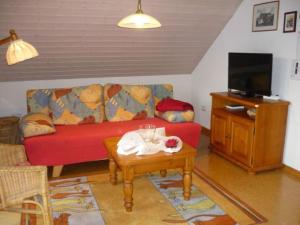 a living room with a red couch and a table at Close-up view inside the Vorbek house in Bärenbach
