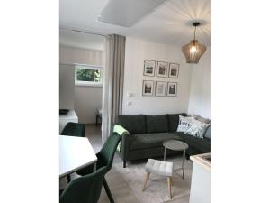 a living room with a green couch and a table at Holiday apartment with 1 bedroom in Oberbach