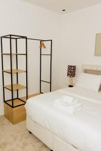 una camera con un letto bianco e una libreria di Studio Luma Dakar a Dakar