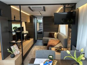 a living room with a couch and a tv at Trailer in 03058 with swimming pool in Haasow