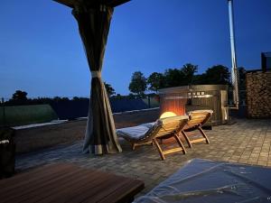 a patio with two chairs and a fire place at Trailer in 03058 with swimming pool in Haasow