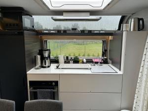 an rv kitchen with a sink and a window at Trailer in 03058 with swimming pool in Haasow