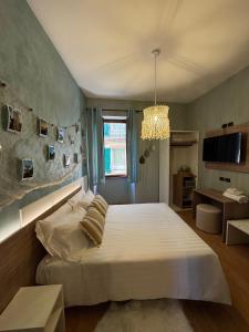 a bedroom with a large white bed and a chandelier at Centro Storico Suites Sarnico in Sarnico