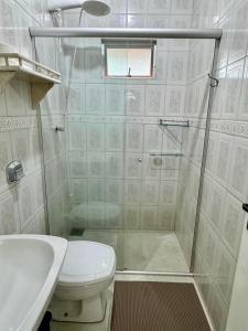a bathroom with a shower and a toilet and a sink at Casa Completa litoral SC com 4 qtos com ar condicionado e Aceita Pets in Itapema +31 photos