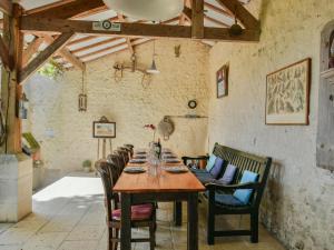 a dining room with a wooden table and chairs at Maswari en Drapeau in Lusignac
