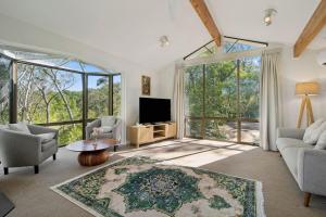 a living room with a tv and large windows at Alencon in Blackheath