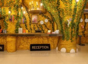 a restaurant with a yellow wall with a sign that reads reception at Tiger Complex Inn in Patong Beach