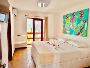 Un dormitorio con dos camas y un cuadro en la pared. en Pousada Casa Palo, en Itacaré 28 fotos más