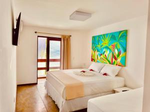 Un dormitorio con dos camas y un cuadro en la pared. en Pousada Casa Palo, en Itacaré