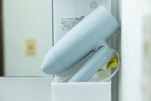 a white hairdryer sitting on top of a wall at 那須Bitsは1棟貸で愛犬と過ごせる宿でBBQ無料プロジェクター完備 in Nasu