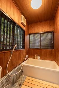 a bathroom with a bath tub in a wooden room at 那須Bitsは1棟貸で愛犬と過ごせる宿でBBQ無料プロジェクター完備 in Nasu +70 photos