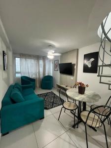 a living room with a blue couch and a table at Israel Flat Tambau-Flat 409 COBERTURA in João Pessoa