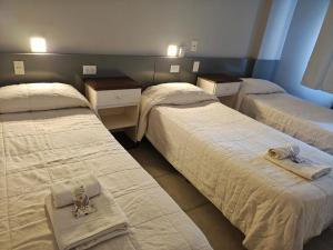 a room with three beds with towels on them at Hotel Venezia in Mar del Plata