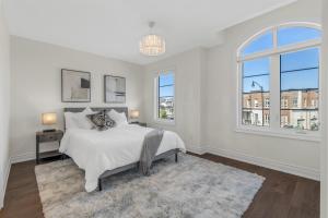 um quarto branco com uma cama e duas janelas em Executive 5BR-4BATH Detached Bramp/Miss Border em Brampton