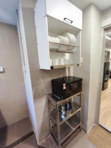 Ayu Blue Lagoon PD by GPH في Gua Sai: مطبخ مع رف وصحون وميكروويف