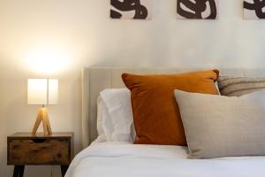 uma cama com almofadas laranja e uma mesa com um candeeiro em Executive 5BR-4BATH Detached Bramp/Miss Border em Brampton