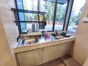 a kitchen with a sink and a window at Ayu Blue Lagoon PD by GPH in Port Dickson