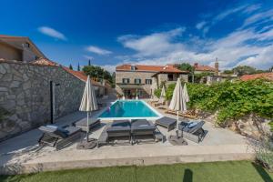 RušićiにあるLuxury villa with a swimming pool Mocici, Dubrovnik - 14900の家の前のスイミングプール(椅子、パラソル付)