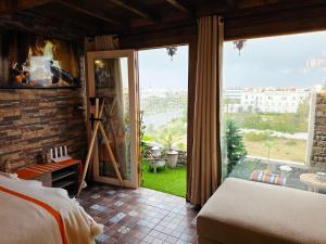 um quarto com uma lareira, uma cama e uma janela grande em Rooftop studio with ocean view em Essaouira