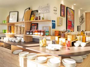 a counter with plates and other items on it at ibis Styles Cabriès Aix-en-Provence TGV in Cabriès