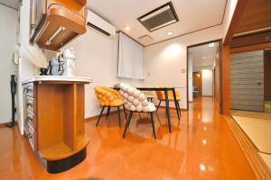 a kitchen with a table and chairs in a room at LIJ Stay Morinomiya 5BedRooms in Osaka