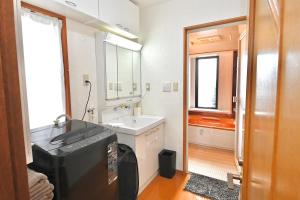 a bathroom with a sink and a large mirror at LIJ Stay Morinomiya 5BedRooms in Osaka +48 photos