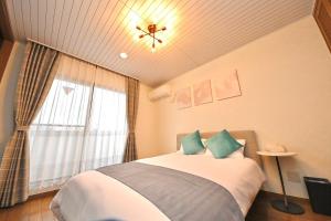 a bedroom with a large bed and a window at LIJ Stay Morinomiya 5BedRooms in Osaka
