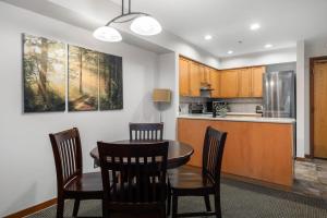 a kitchen and dining room with a table and chairs at Cozy 1BR, steps from Creekside Gondola by Harmony Whistler Vacations in Whistler