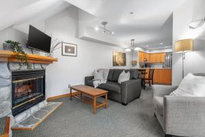 a living room with a couch and a fireplace at Cozy 1BR, steps from Creekside Gondola by Harmony Whistler Vacations in Whistler