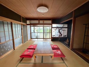 a room with a table and two red cushioned chairs at 瀬戸内庵Setouchian in Takamatsu