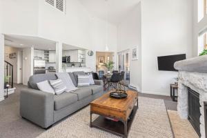 a living room with a couch and a fireplace at Olympic Plaza Views with Pool and Hot Tub by Harmony Whistler in Whistler