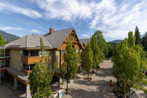 an aerial view of a house with trees in front at Olympic Plaza Views with Pool and Hot Tub by Harmony Whistler in Whistler