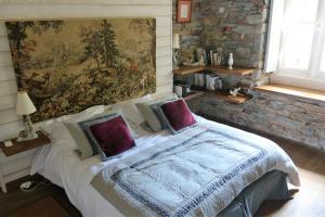 a bedroom with a bed with a painting on the wall at Cottage du Manoir de Trégaray in Sixt-sur-Aff +30 photos