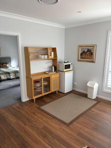 Bundanoon Rochester Guest House في بوندانون: غرفة بسرير وغرفة مع مطبخ