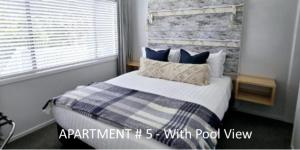 a bedroom with a bed with a blue and white blanket at Stay n Play n Russell in Russell +27 photos