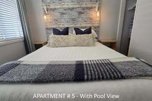 a bedroom with a bed with a wooden wall at Stay n Play n Russell in Russell