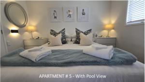 a bedroom with a large bed with white sheets and pillows at Stay n Play n Russell in Russell