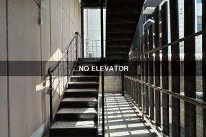 a staircase in a building with a no elevator sign at goom Monthly Nakasu JOJO in Fukuoka