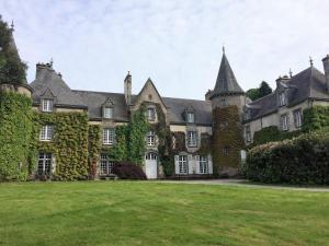 an old castle with a green lawn in front of it at Cottage du Manoir de Trégaray in Sixt-sur-Aff