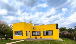 a yellow house with a picnic table in front of it at Cabañas La Soñada in Chajarí