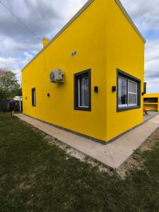 uma casa amarela com duas janelas do lado em Cabañas La Soñada em Chajarí