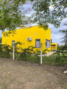 uma casa amarela no meio de um campo em Cabañas La Soñada em Chajarí