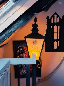 a lamp on the side of a house with a wall at Rose Cottage in Whitby