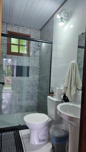 a bathroom with a toilet and a sink and a shower at Chalés da Jack in Angra dos Reis