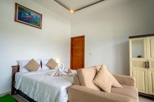 a bedroom with a bed and a couch and a window at Break Villa Kintamani in Kintamani