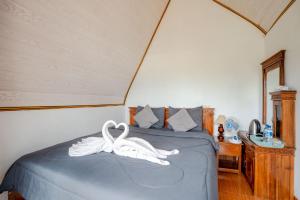 um quarto com uma cama com cisnes brancos em Break Villa Kintamani em Kintamani