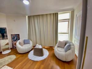 un soggiorno con due sedie e un tavolo di 2Br Stanley Sea View a Banī Ghālib